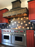 This modern kitchen features a stainless steel stove, red cabinets, checkered backsplash, and a ProlineRangeHoods.com hood.