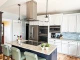 Contemporary kitchen with bar stools and ProlineRangeHoods.com's Island Range Hood (Model PLFI 544) in stainless steel.