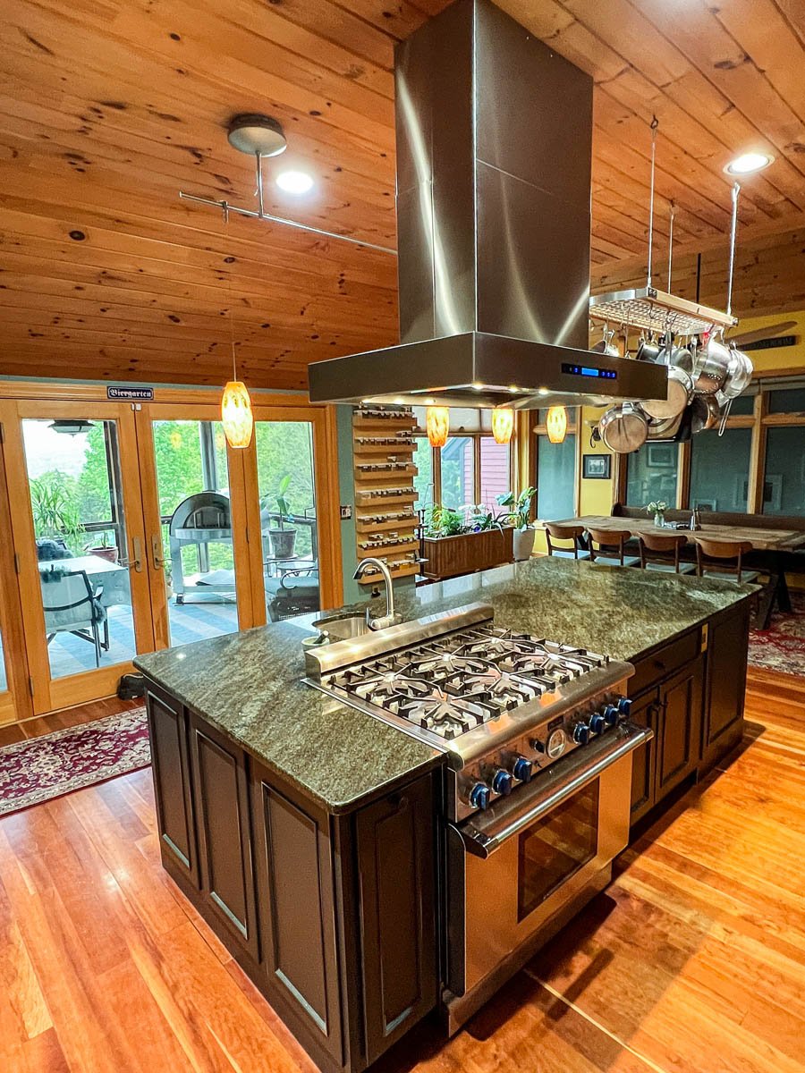 A contemporary kitchen with a central island and ProlineRangeHoods.com PLFI 755 Range Hood offers 1100 CFM for efficient ventilation.