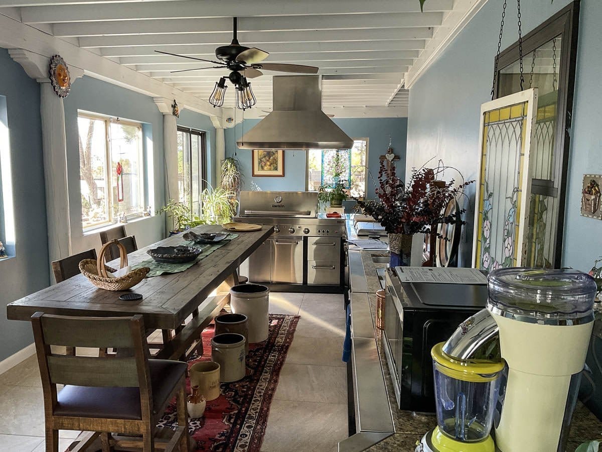 The bright kitchen features stainless steel appliances and decor, including the ProlineRangeHoods.com PLJI 109 Island.