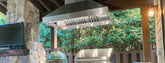Outdoor kitchen with a grill, green ceramic smoker, stone pillar, TV under a vent hood. ProlineRangeHoods.com.