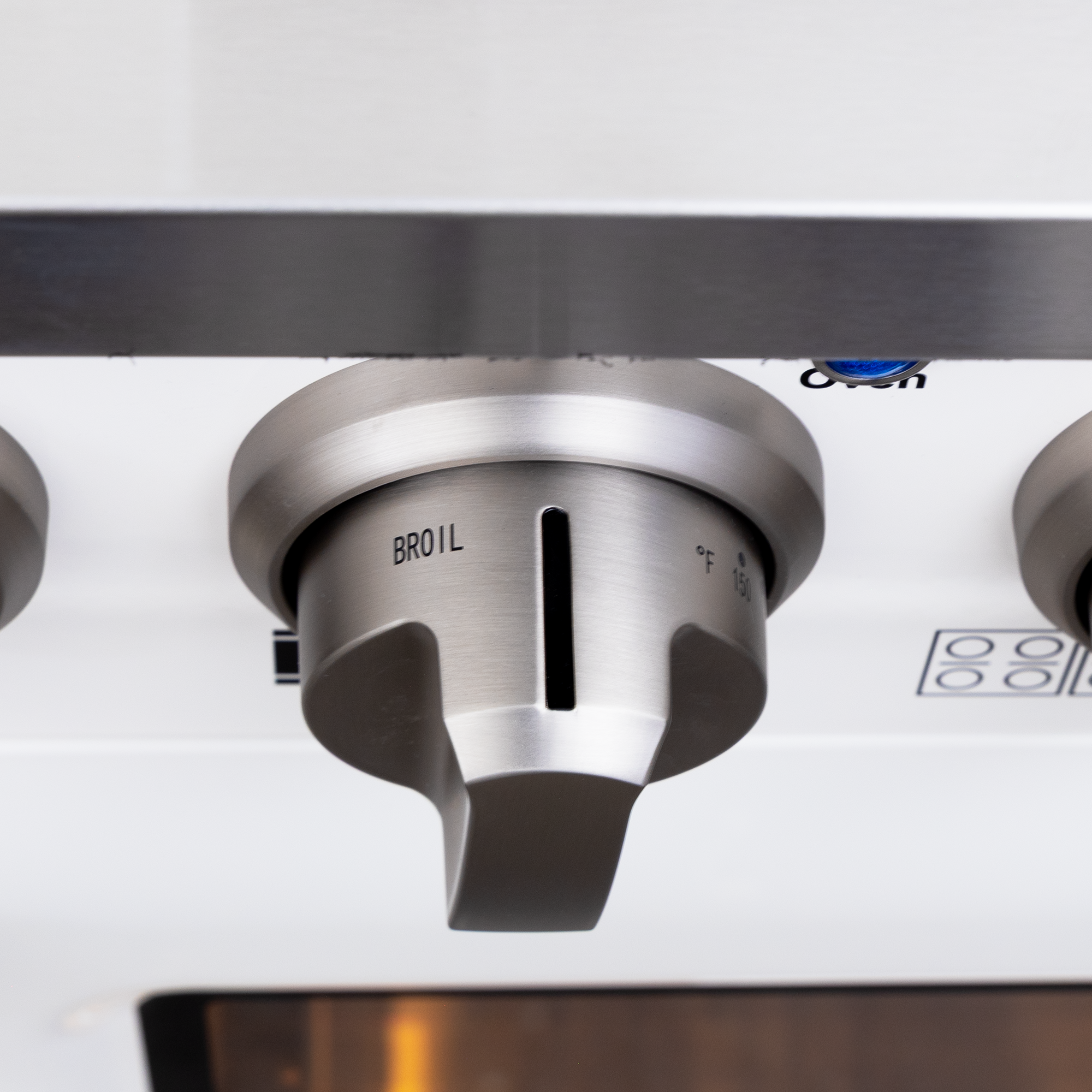 Close-up of Proline PLSR 48GG Range knob set to broil; white, 8 burners, double oven, griddle. ProlineRangeHoods.com.