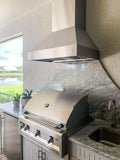 Outdoor kitchen with outdoor 304 stainless grill, marble backsplash, sink, plants by window, ProlineRangeHoods.com.