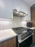 Modern kitchen with a 430 stainless steel gas stove, Proline PLJW 185 Slim under cabinet range hood by ProlineRangeHoods.com (ducted, 600 CFM, stainless steel), tiled backsplash, and a counter with an air fryer.