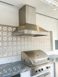 Stainless steel grill and hood on marble, glass block wall, ProlineRangeHoods.com PLGW 104 HE, 1200-1300 CFM.