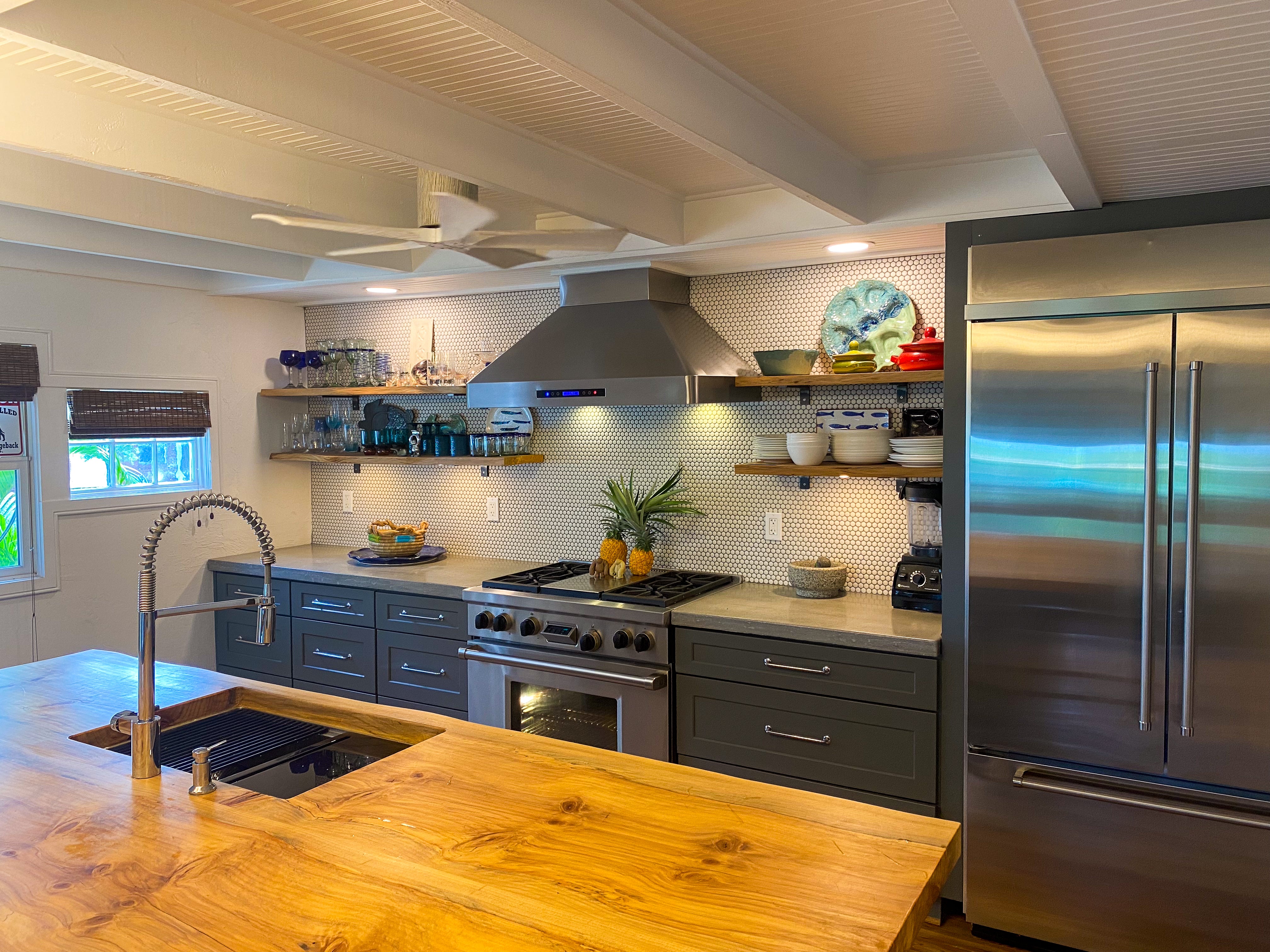 Modern kitchen with stainless appliances, open shelves, wood island countertop. ProlineRangeHoods.com.