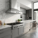 Modern kitchen with gray cabinets, marble counters, ProlineRangeHoods.com gas range & hood bundle; barstools by window.