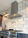 Modern kitchen with stainless stove, ProlineRangeHoods.com Wall Mounted Hood for ventilation (600/1200 CFM), brick wall. PLFW 520.48