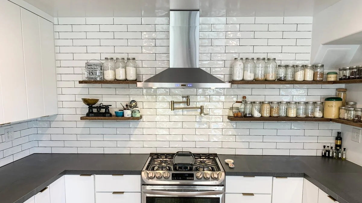 Modern kitchen with white cabinets, subway tile backsplash, open shelves, stove. ProlineRangeHoods.com.