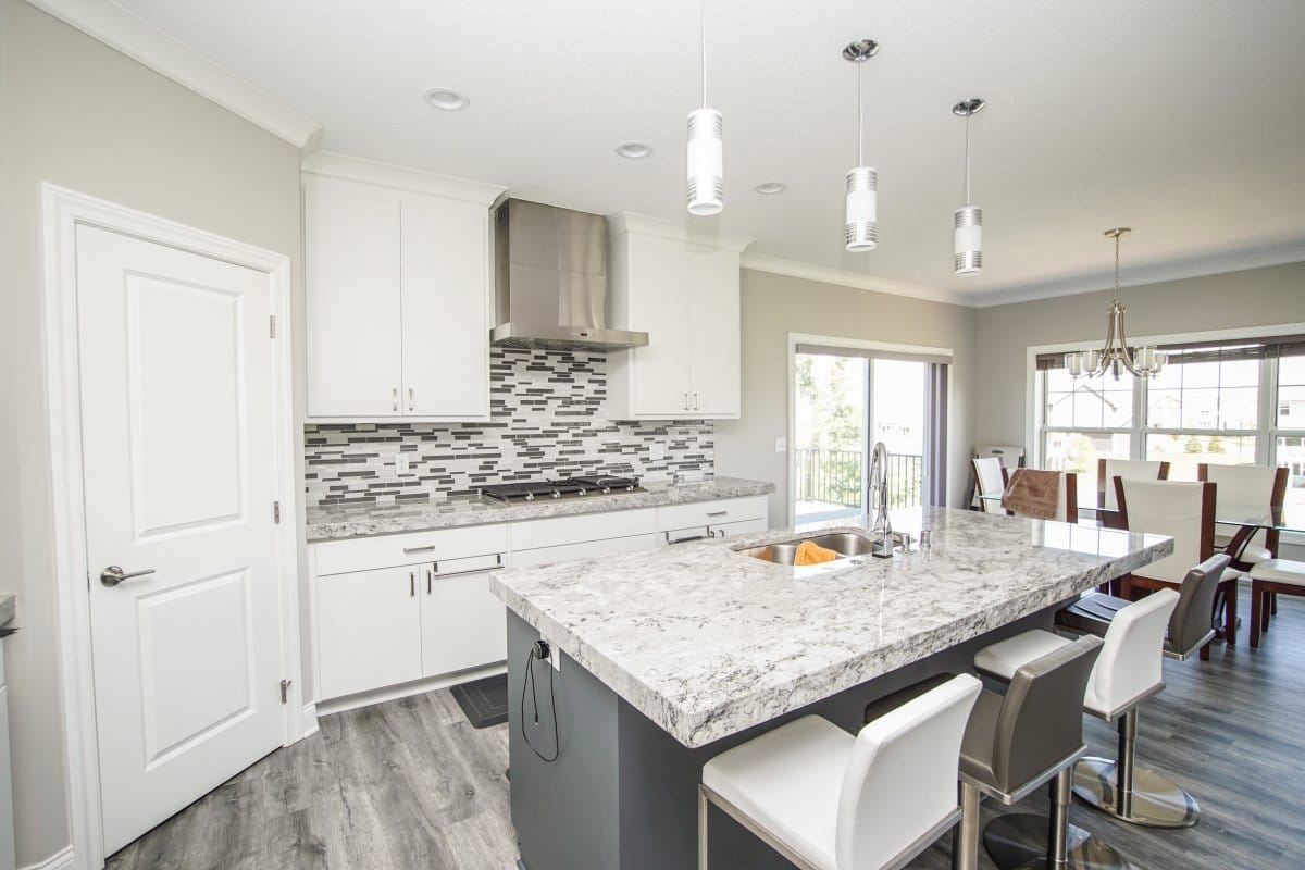 Contemporary kitchen with white cabinets, marble island, and ProlineRangeHoods.com Proline PLFW 750 Hood in stainless steel.