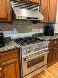 Modern kitchen with a stainless stove, ProlineRangeHoods.com PLFW 115 range hood, wood cabinets, granite countertops. PLFW 115.30