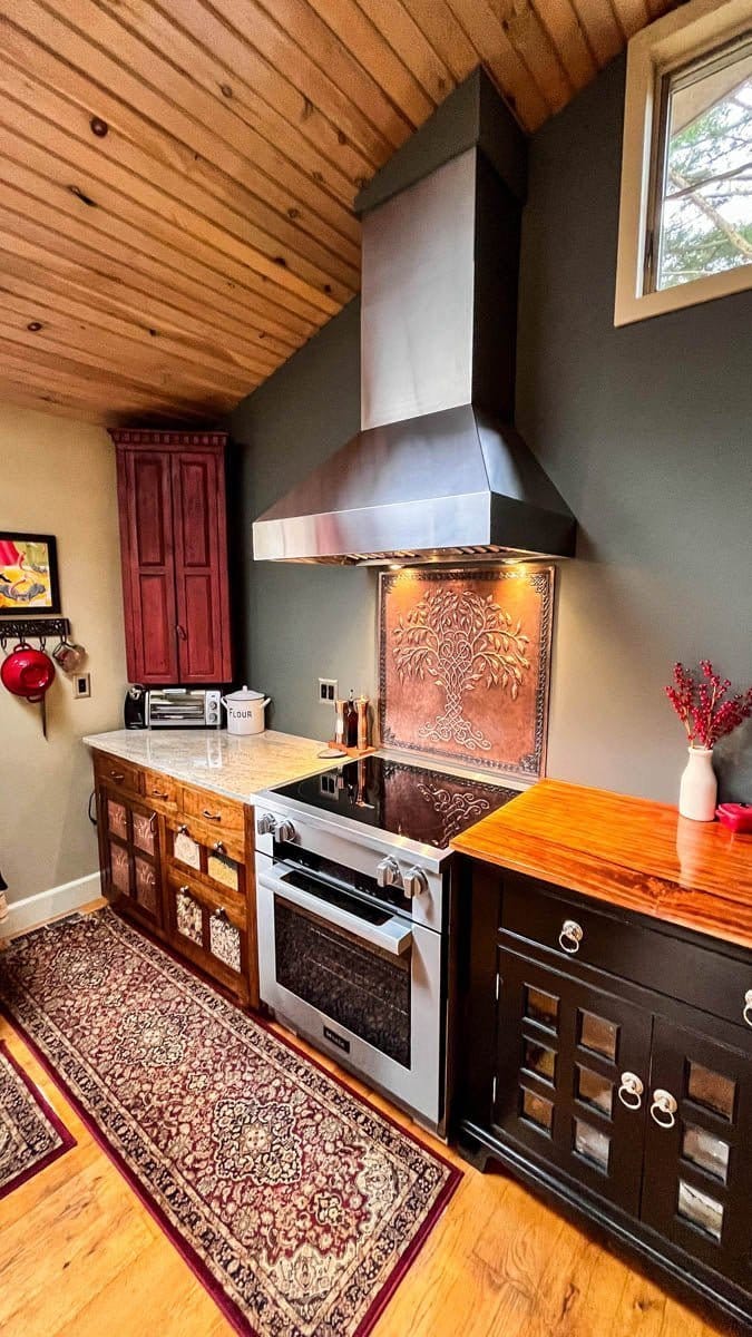 Modern kitchen with wood cabinets, patterned rug, Proline PLJW 104 range hood; ProlineRangeHoods.com visible.