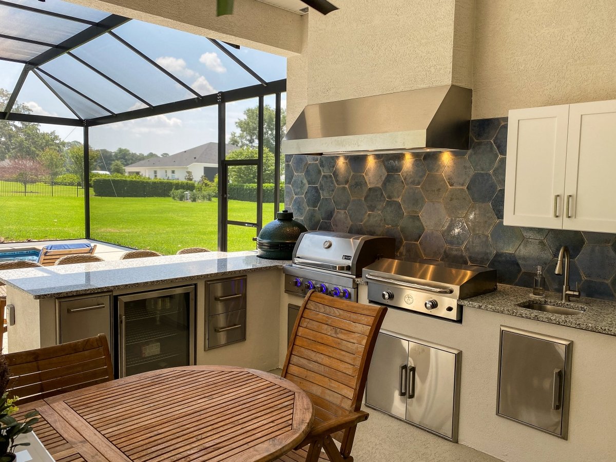 Outdoor kitchen featuring the Proline PLJW 105 from ProlineRangeHoods.com, a powerful outdoor-rated range hood, plus grill and more.