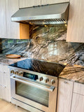 This compact kitchen features a ProlineRangeHoods.com PLJW 121 hood, ductless, with marble countertops and backsplash.