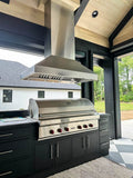 Outdoor kitchen with ProlineRangeHoods.com ProVI Island Hood in stainless steel, sleek black cabinets, wooden ceiling.