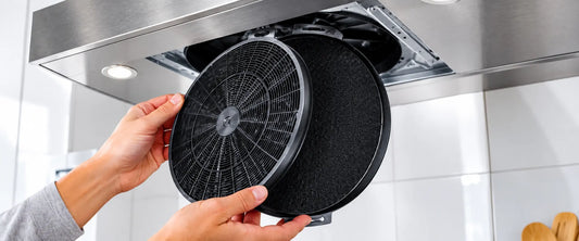 Person replacing a charcoal range hood filter in a kitchen range hood