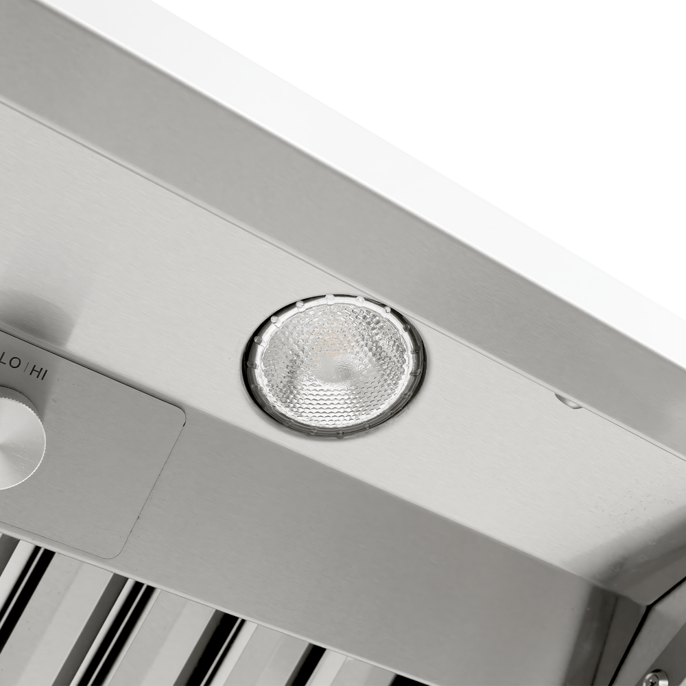Round light fixture on Proline Range Hoods PLGW 104 HE in stainless steel, control knob visible. ProlineRangeHoods.com.