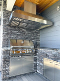 PLGW WC BBQ Pro stainless steel range hood from ProlineRangeHoods.com above a stone outdoor kitchen.
