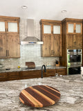 Proline King Air stainless steel wall-mounted range hood above a stovetop. ProlineRangeHoods.com.