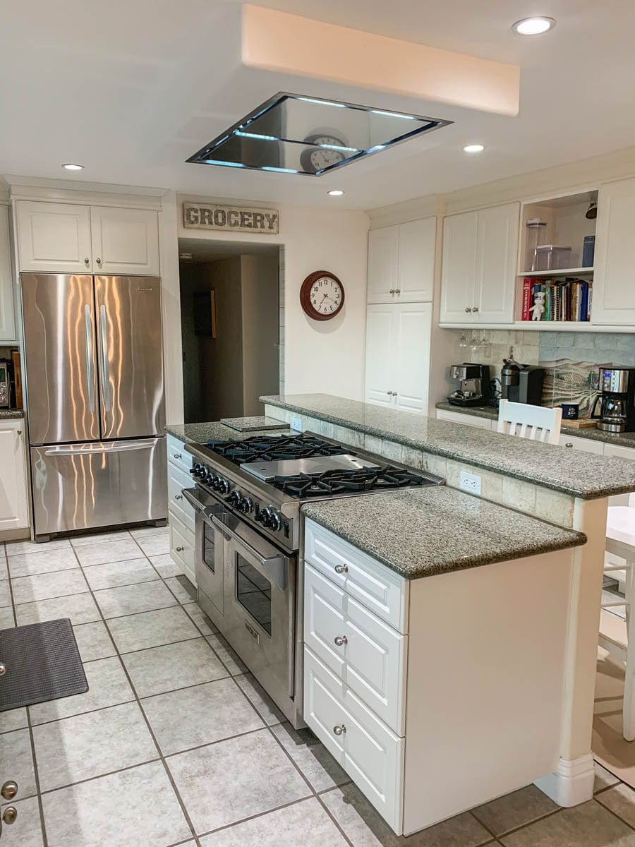 Modern kitchen with white cabinets, granite countertops, "Grocery" sign, Proline 42" range hood, ProlineRangeHoods.com.