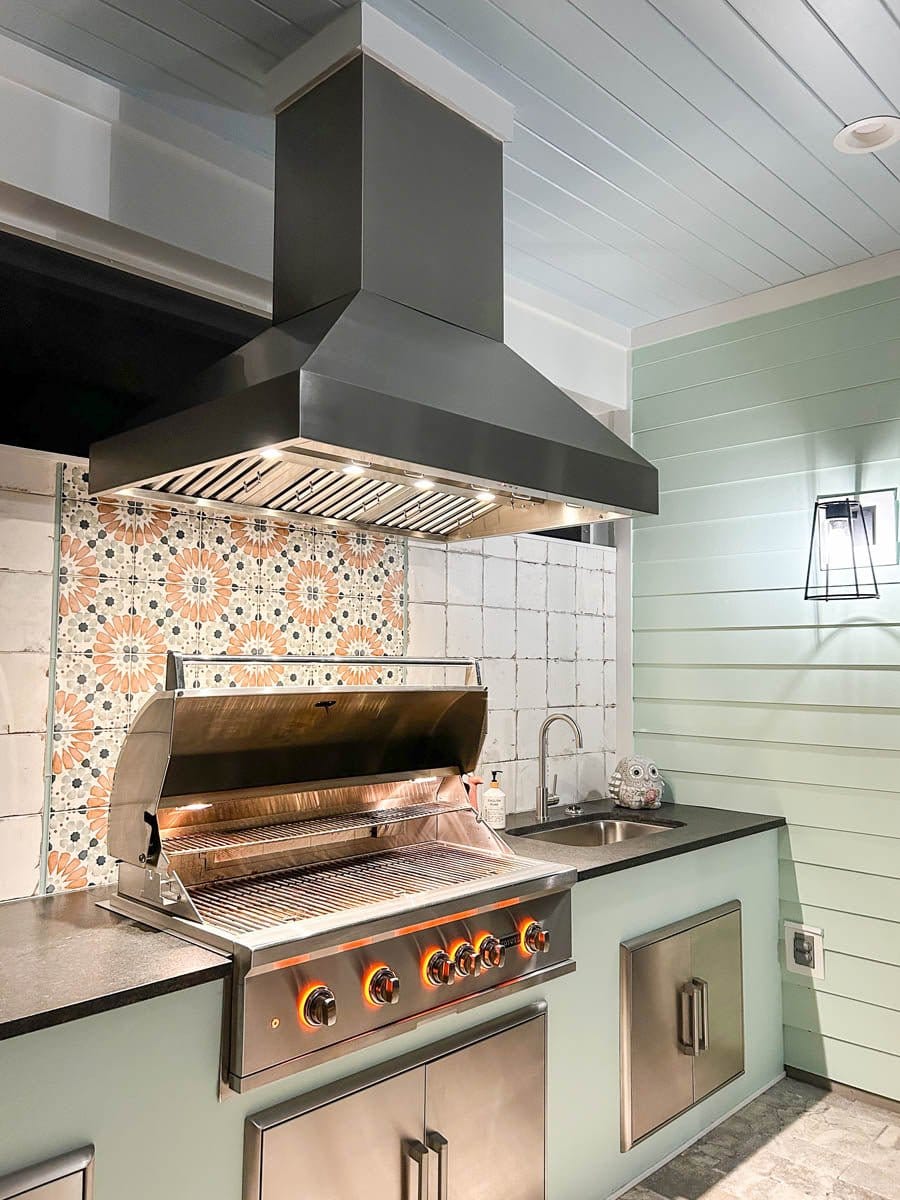Outdoor kitchen with ProlineRangeHoods.com Island Range Hood, 1200 CFM dual motors, stainless steel finish, and grill.