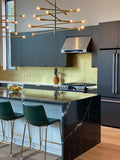 Modern kitchen with dark cabinets, marble island, green barstools, and ProlineRangeHoods.com PLJW 102 range hood.