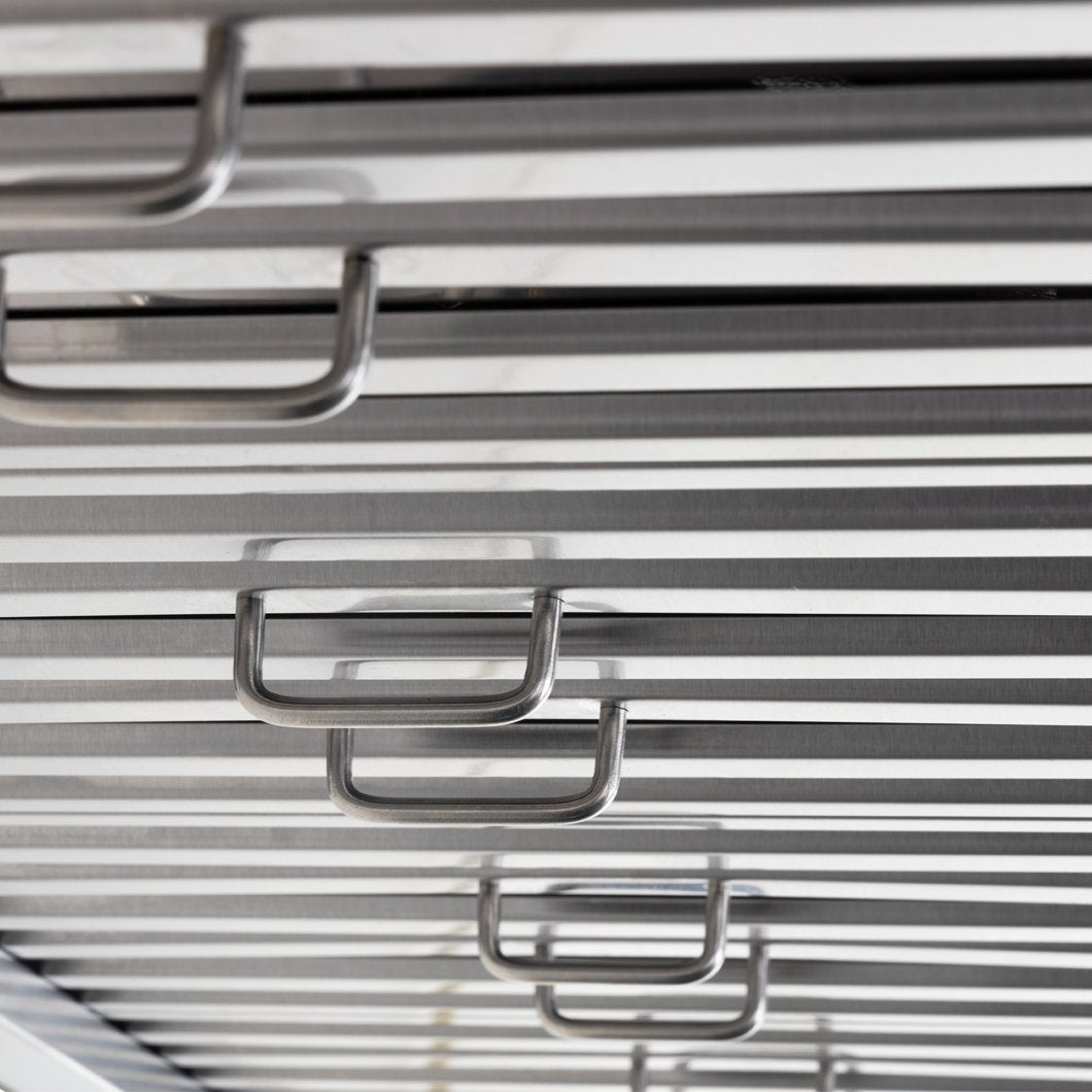 Close-up of horizontal metallic bars with U-shaped handles, reminiscent of the sleek design found in ProlineRangeHoods.com.